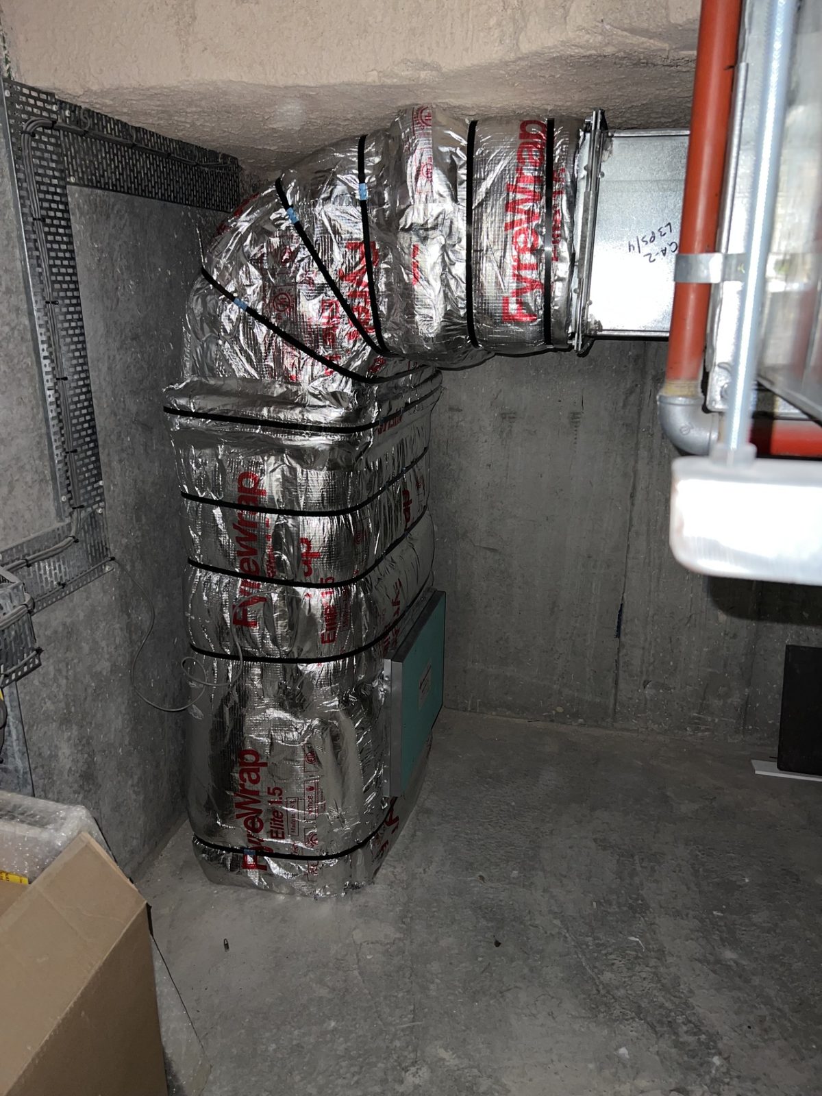 FyreWrap Elite 1.5 flexible fire-rated wrap installed on vertical HVAC ductwork in a Sydney plant room